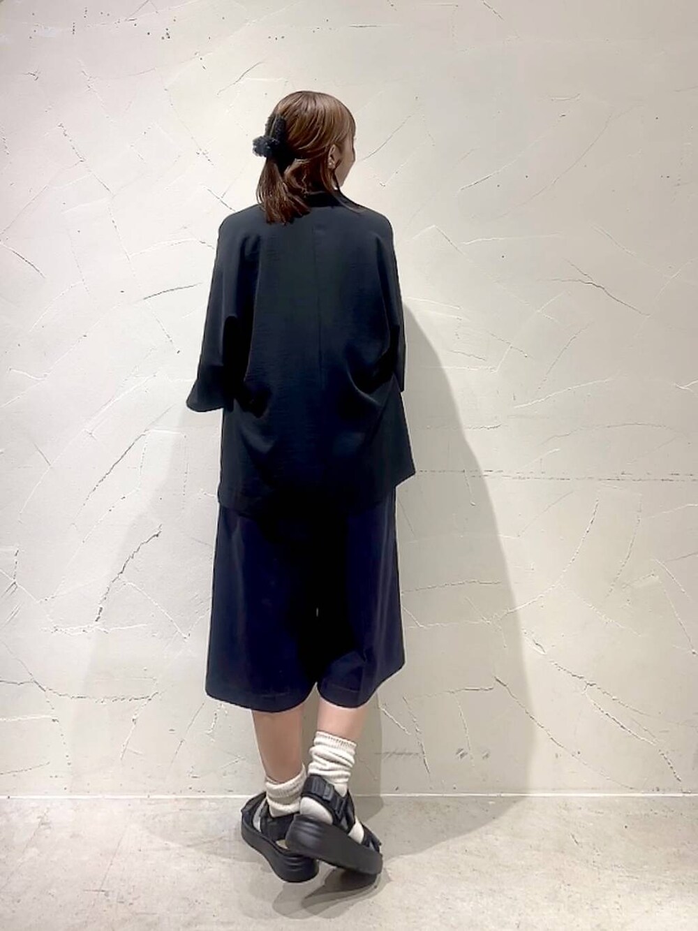 ホワイト系のTシャツ/カットソー、ブルー系のその他パンツ、ブラック系のサンダルを着用したレディースの春コーディネートの5枚目の写真