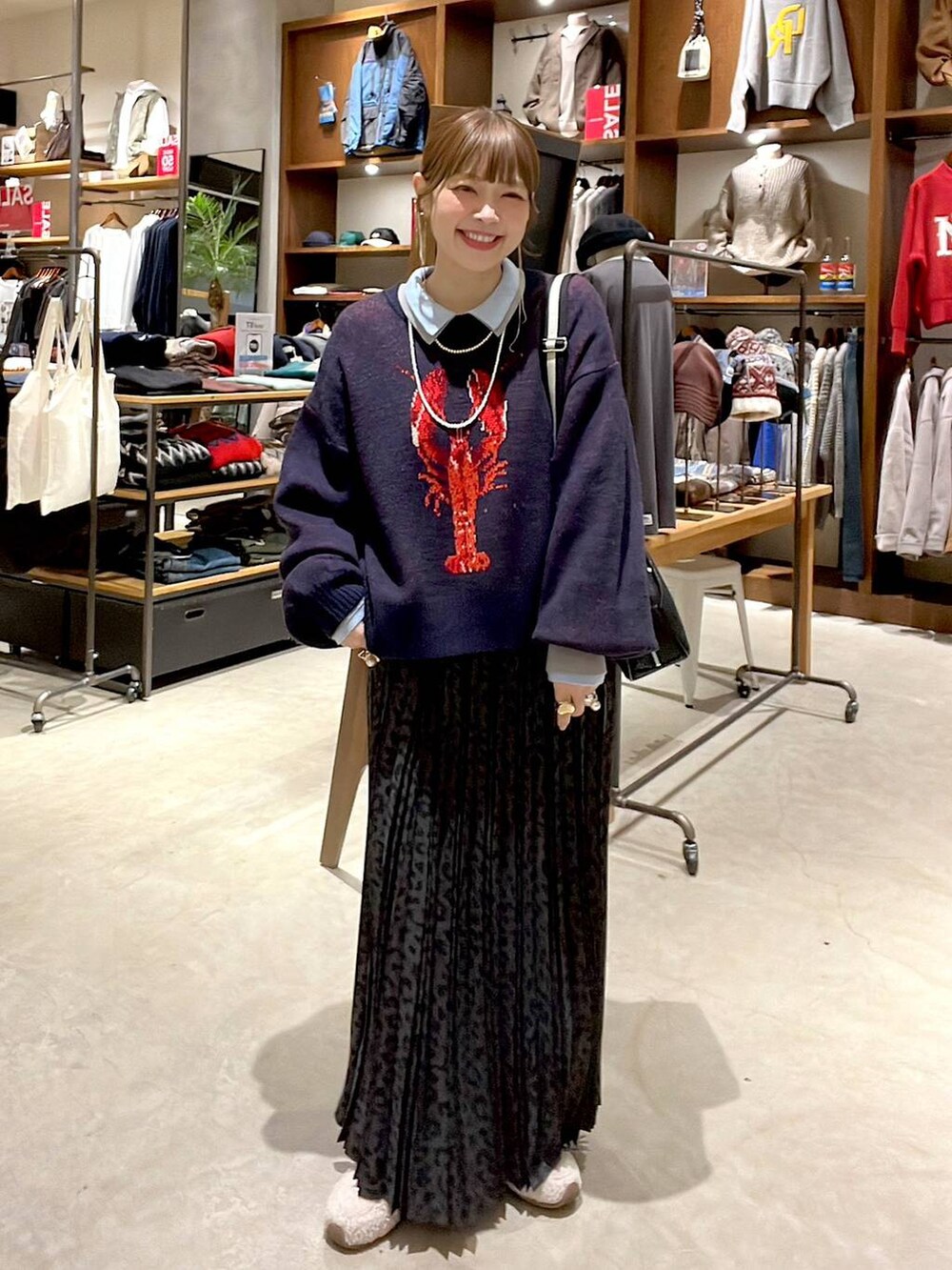 グレー系のスカート、ブラック系のショルダーバッグ、ベージュ系のスニーカーを着用したレディースの冬コーディネートの6枚目の写真