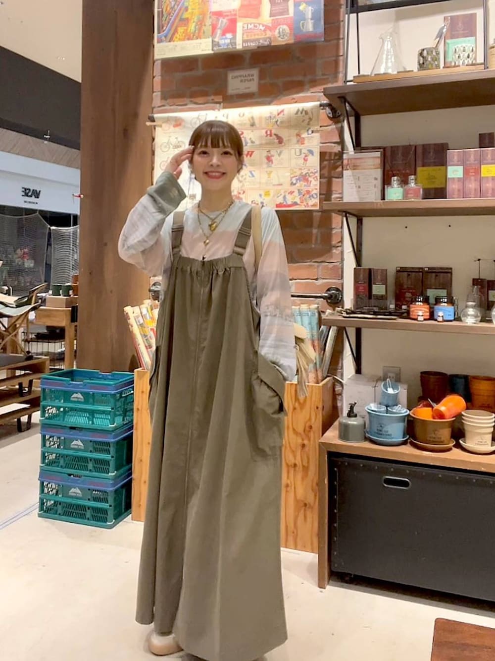 ベージュ系のTシャツ/カットソー、ベージュ系のショルダーバッグ、グリーン系のジャンパースカートを着用したレディースの夏コーディネートの2枚目の写真