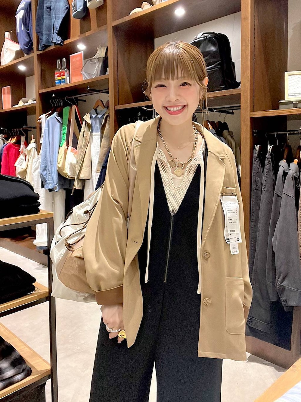 ベージュ系のトートバッグ、ブラック系のサロペット/オーバーオール、ホワイト系のTシャツ/カットソーを着用したレディースの冬コーディネートの5枚目の写真