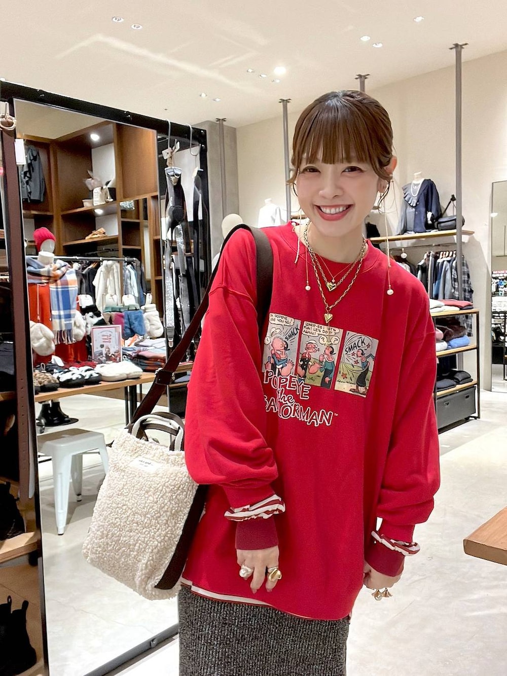 レッド系のTシャツ/カットソー、ホワイト系のスカート、ベージュ系のトートバッグを着用したレディースの冬コーディネートの7枚目の写真