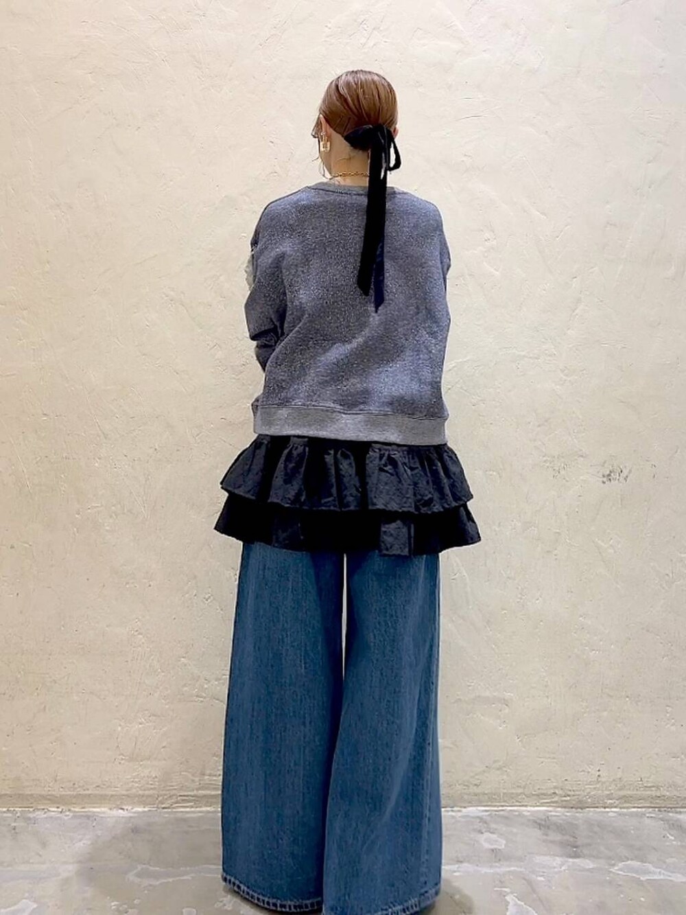 シルバー系のバレエシューズ、ブルー系のデニムパンツ、ブルー系のスウェットを着用したレディースの冬コーディネートの4枚目の写真