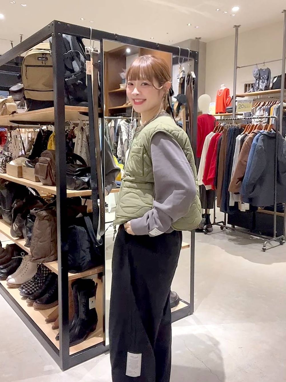 グリーン系のベスト、グレー系のTシャツ/カットソーを着用したレディースの秋コーディネートの2枚目の写真