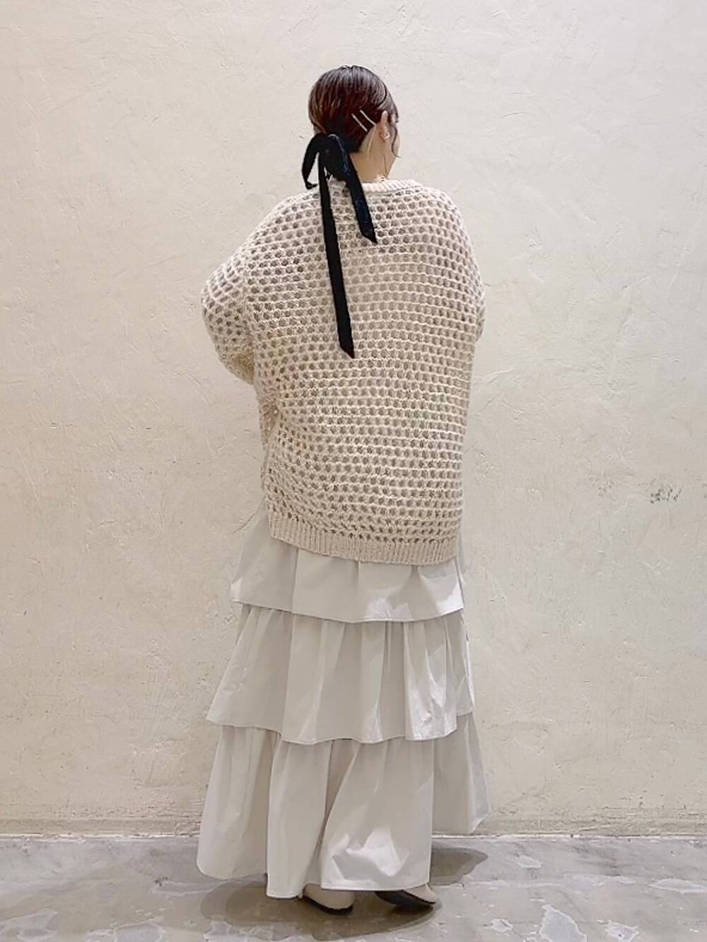 ホワイト系のパンプス、ベージュ系のニット/セーター、ベージュ系のスカートを着用したレディースの冬コーディネートの4枚目の写真