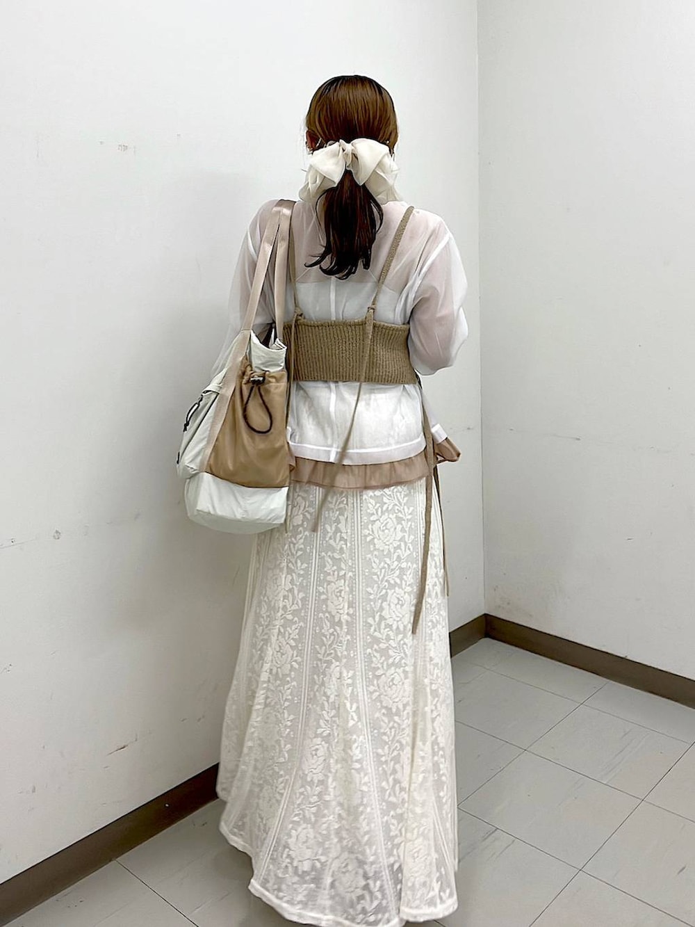 ベージュ系のスニーカー、ベージュ系のトートバッグ、ベージュ系のスカートを着用したレディースの冬コーディネートの4枚目の写真