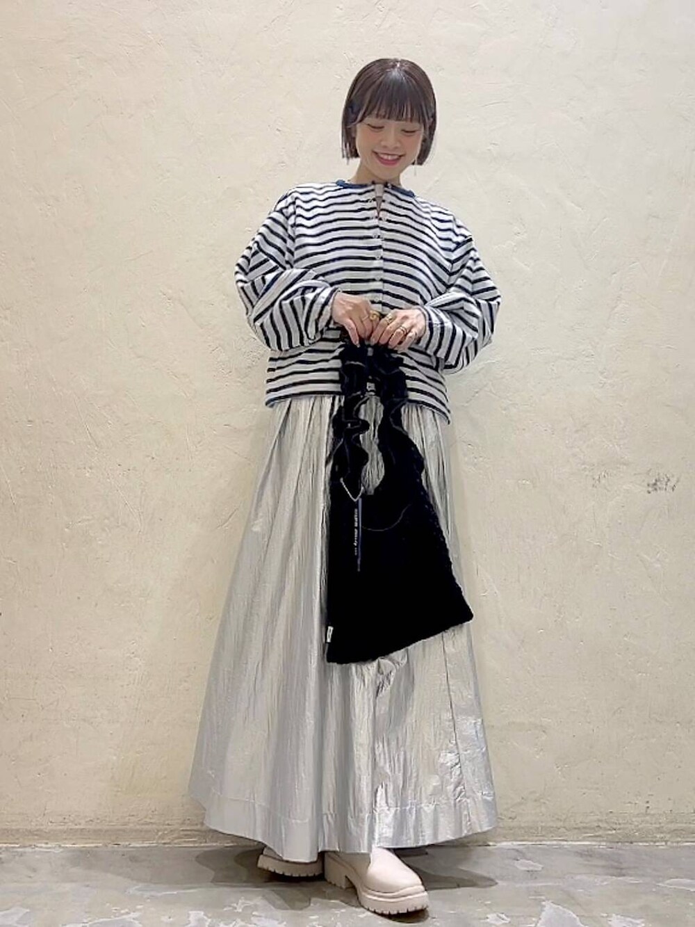 ベージュ系のブーツ、ブラック系のトートバッグ、ホワイト系のTシャツ/カットソーを着用したレディースの冬コーディネートの7枚目の写真