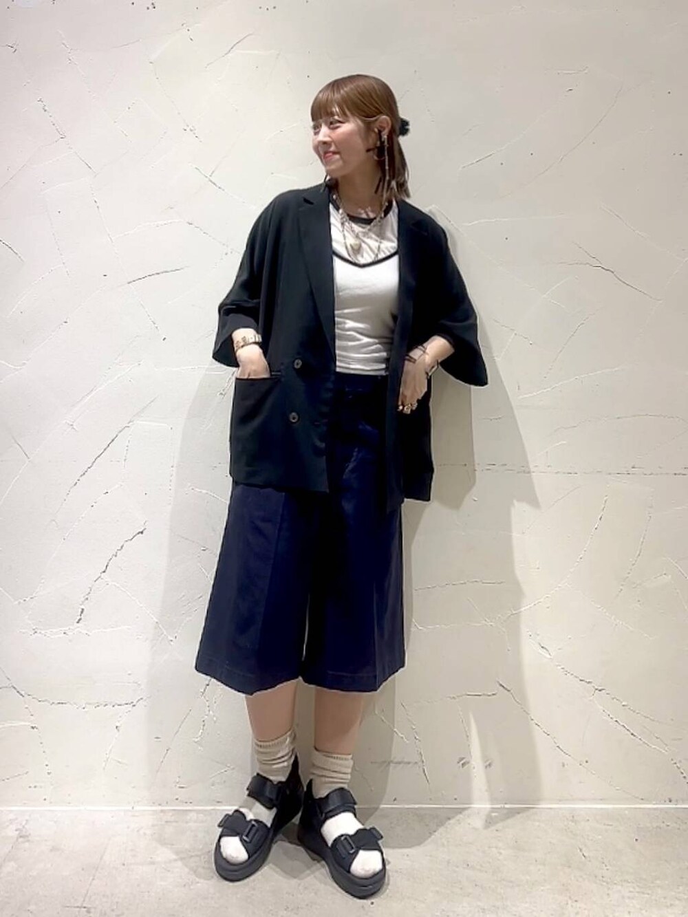 ホワイト系のTシャツ/カットソー、ブルー系のその他パンツ、ブラック系のサンダルを着用したレディースの春コーディネートの2枚目の写真