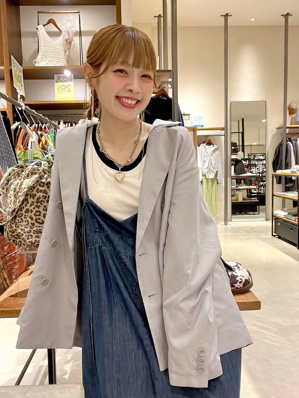 ベージュ系のスニーカー、グレー系のテーラードジャケット、ホワイト系のタンクトップを着用したレディースの春コーディネートの7枚目の写真