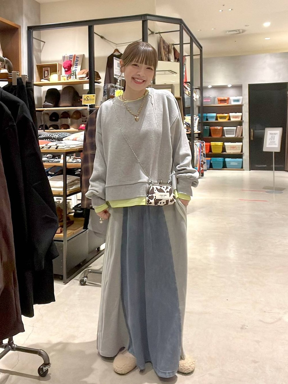 ベージュ系のパンプス、グレー系のスウェット、ブルー系のデニムスカートを着用したレディースの秋コーディネートの7枚目の写真