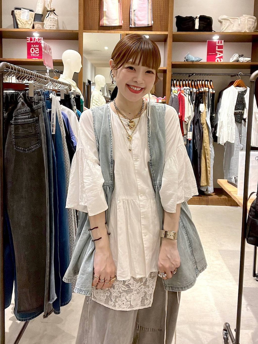 グレー系のその他パンツ、ブルー系のベスト、ホワイト系のシャツ/ブラウスを着用したレディースの夏コーディネートの2枚目の写真