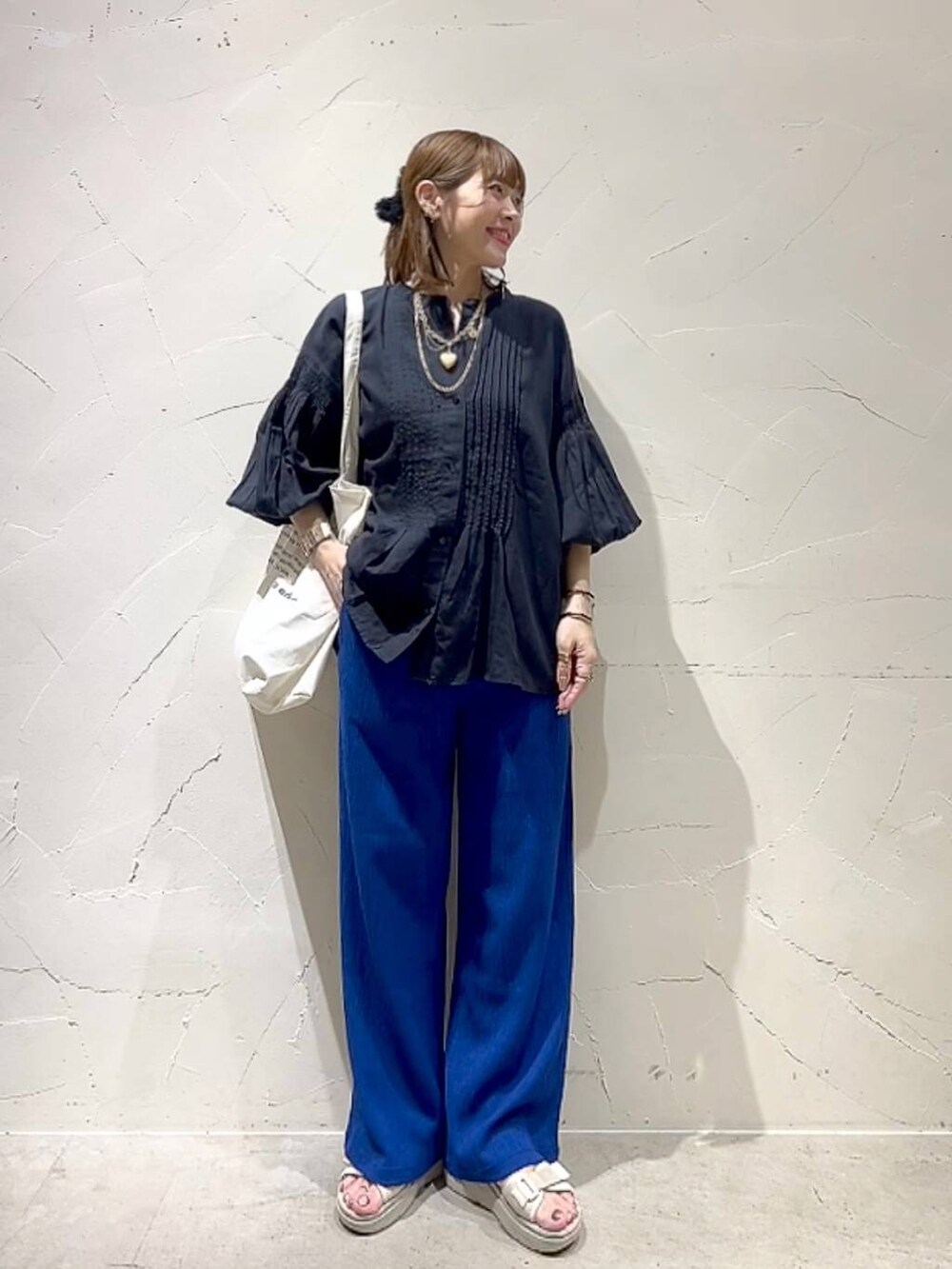 ベージュ系のトートバッグ、ブラック系のシャツ/ブラウス、ブルー系のその他パンツを着用したレディースの春コーディネートの7枚目の写真