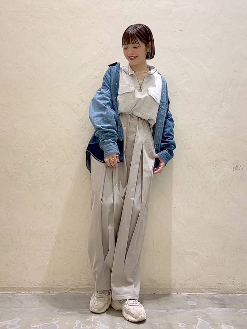 ベージュ系のスウェット、グレー系のチノパンツ、ブルー系のシャツ/ブラウスを着用したレディースの冬コーディネートの6枚目の写真