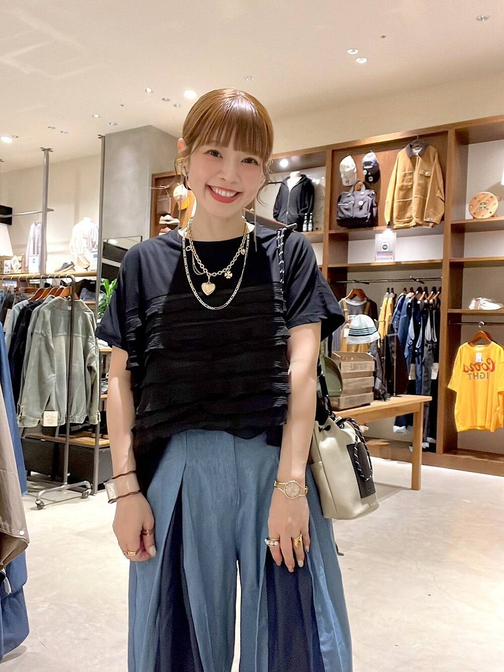 グレー系のショルダーバッグ、ブラック系のTシャツ/カットソー、ゴールド系のネックレスを着用したレディースの秋コーディネートの7枚目の写真