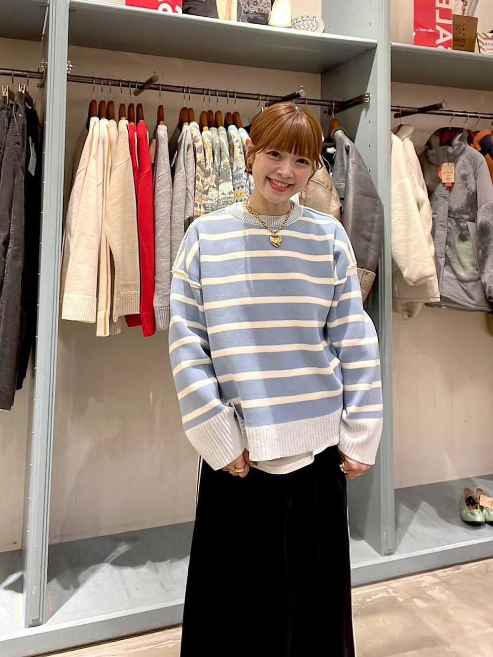 ホワイト系のTシャツ/カットソー、ブラック系のスカート、ベージュ系のニット/セーターを着用したレディースの冬コーディネートの7枚目の写真