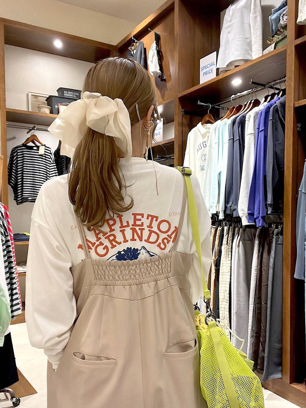 ベージュ系のスニーカー、イエロー系のショルダーバッグ、ホワイト系のヘアゴムを着用したレディースの春コーディネートの3枚目の写真