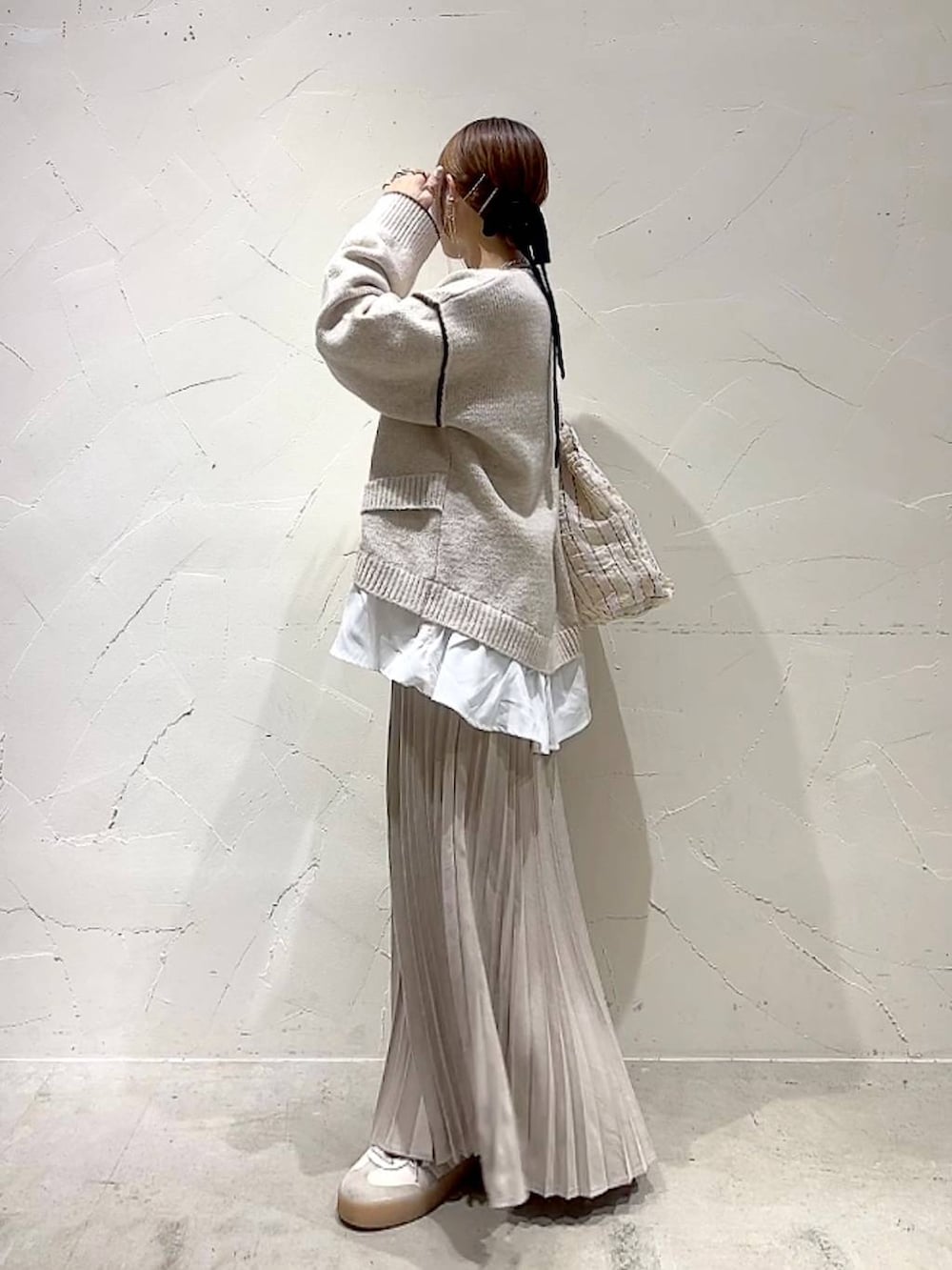 ベージュ系のスカート、その他のトートバッグ、ゴールド系のネックレスを着用したレディースの秋コーディネートの5枚目の写真