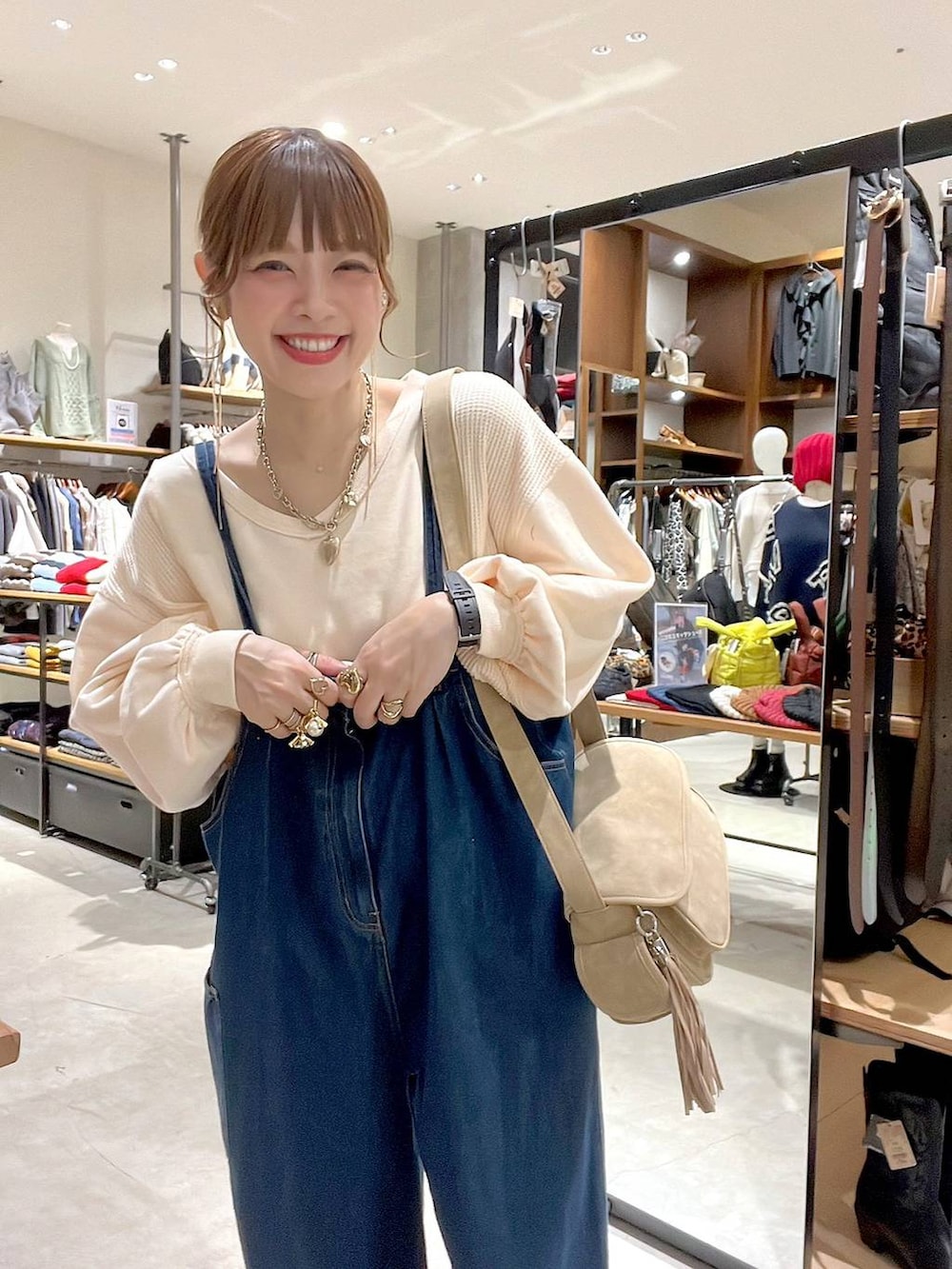 ベージュ系のショルダーバッグ、ブラック系のアナログ腕時計を着用したレディースの秋コーディネートの7枚目の写真