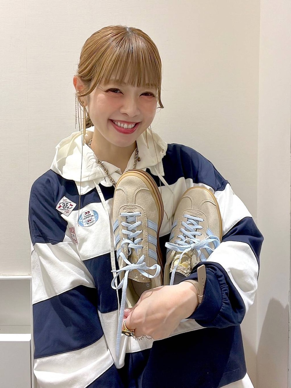 ベージュ系のスニーカー、ホワイト系のシャツ/ブラウス、ブルー系のTシャツ/カットソーを着用したレディースの春コーディネートの2枚目の写真