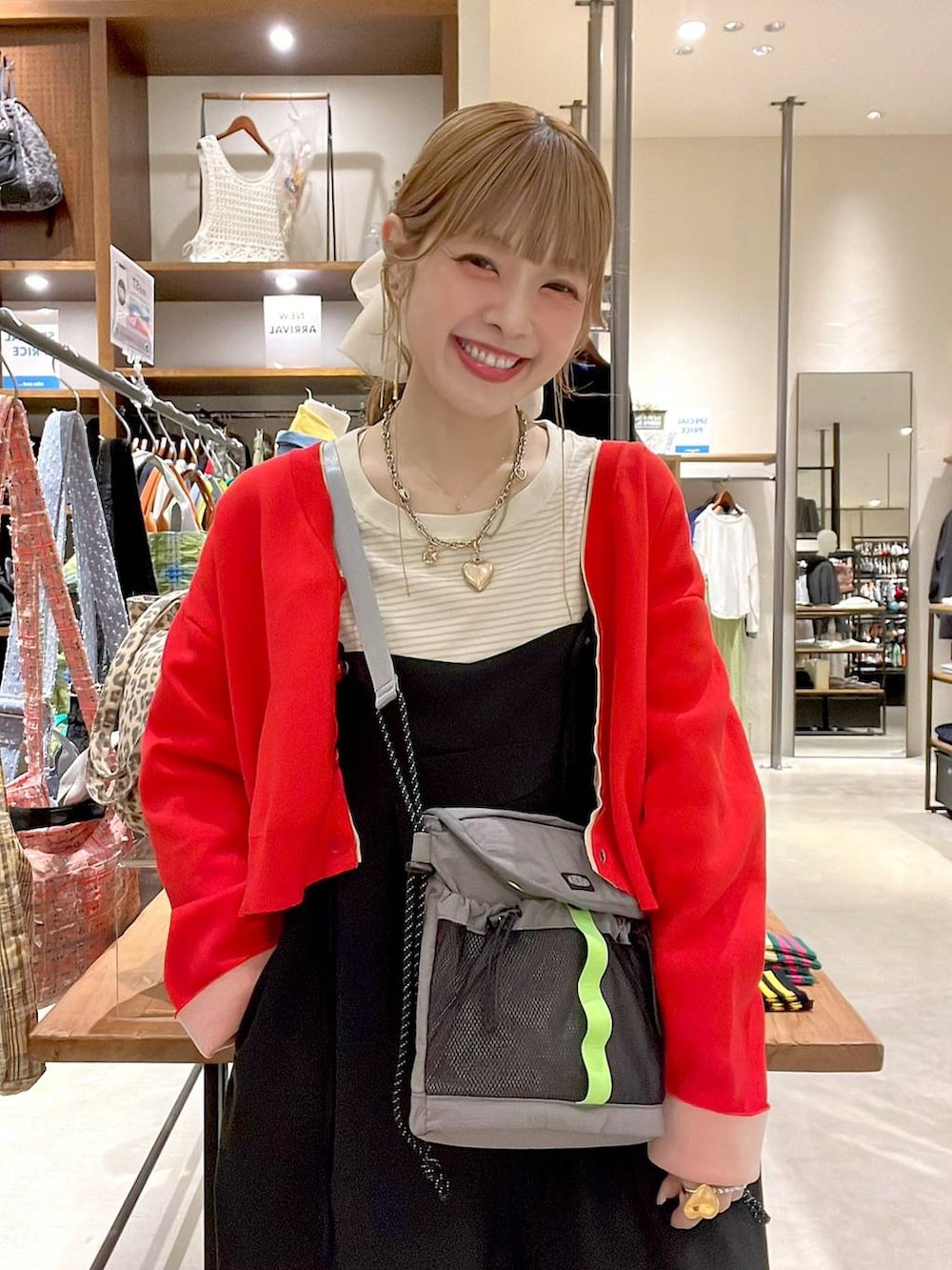 レッド系のカーディガン/ボレロ、ホワイト系のヘアゴムを着用したレディースの春コーディネートの2枚目の写真