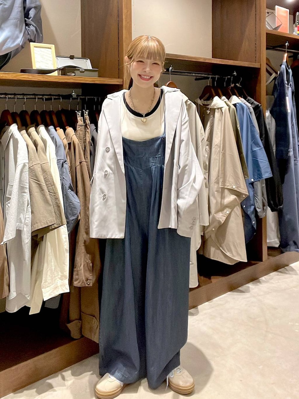 ベージュ系のスニーカー、グレー系のテーラードジャケット、ホワイト系のタンクトップを着用したレディースの春コーディネートの3枚目の写真