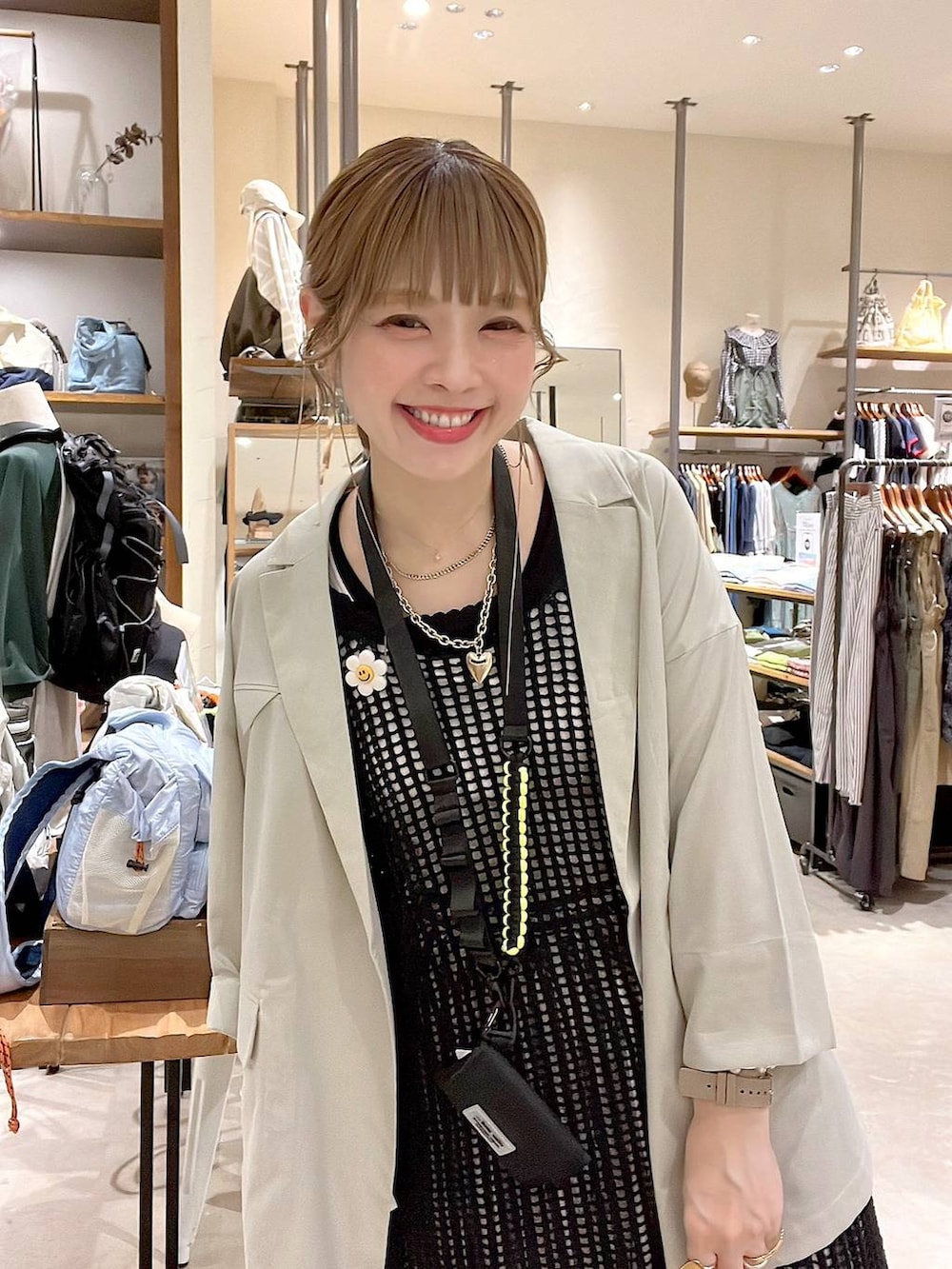 ベージュ系のテーラードジャケット、ブルー系のその他パンツ、ブラック系のワンピースを着用したレディースの春コーディネートの2枚目の写真