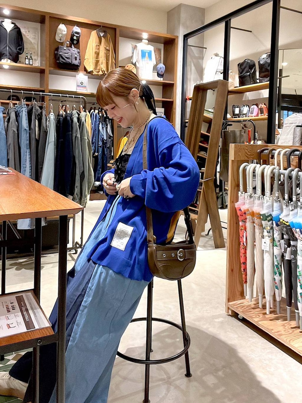 ブラック系のキャミソール、ブラウン系のショルダーバッグを着用したレディースの秋コーディネートの4枚目の写真