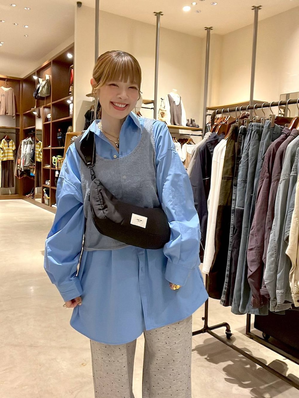 ブルー系のシャツ/ブラウス、ブラック系のショルダーバッグ、ブラウン系のチュニックを着用したレディースの秋コーディネートの3枚目の写真