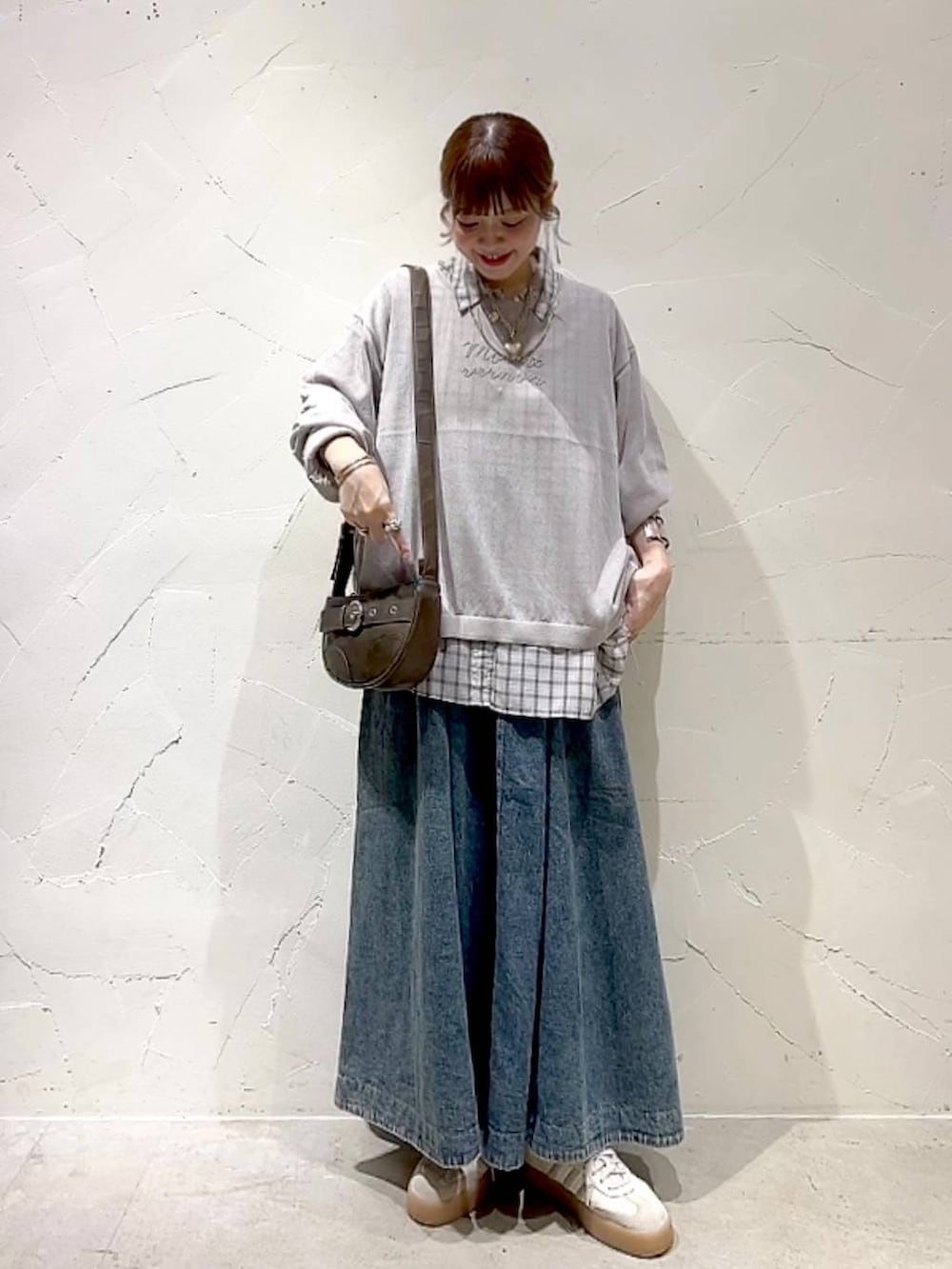 ブルー系のスカート、ホワイト系のシャツ/ブラウス、ブラウン系のショルダーバッグを着用したレディースの秋コーディネートの8枚目の写真