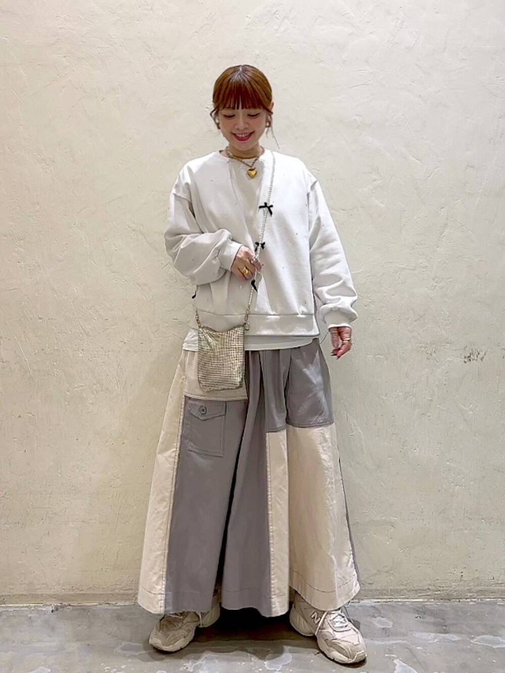 ゴールド系のショルダーバッグ、ホワイト系のTシャツ/カットソー、ホワイト系のその他トップスを着用したレディースの冬コーディネートの9枚目の写真