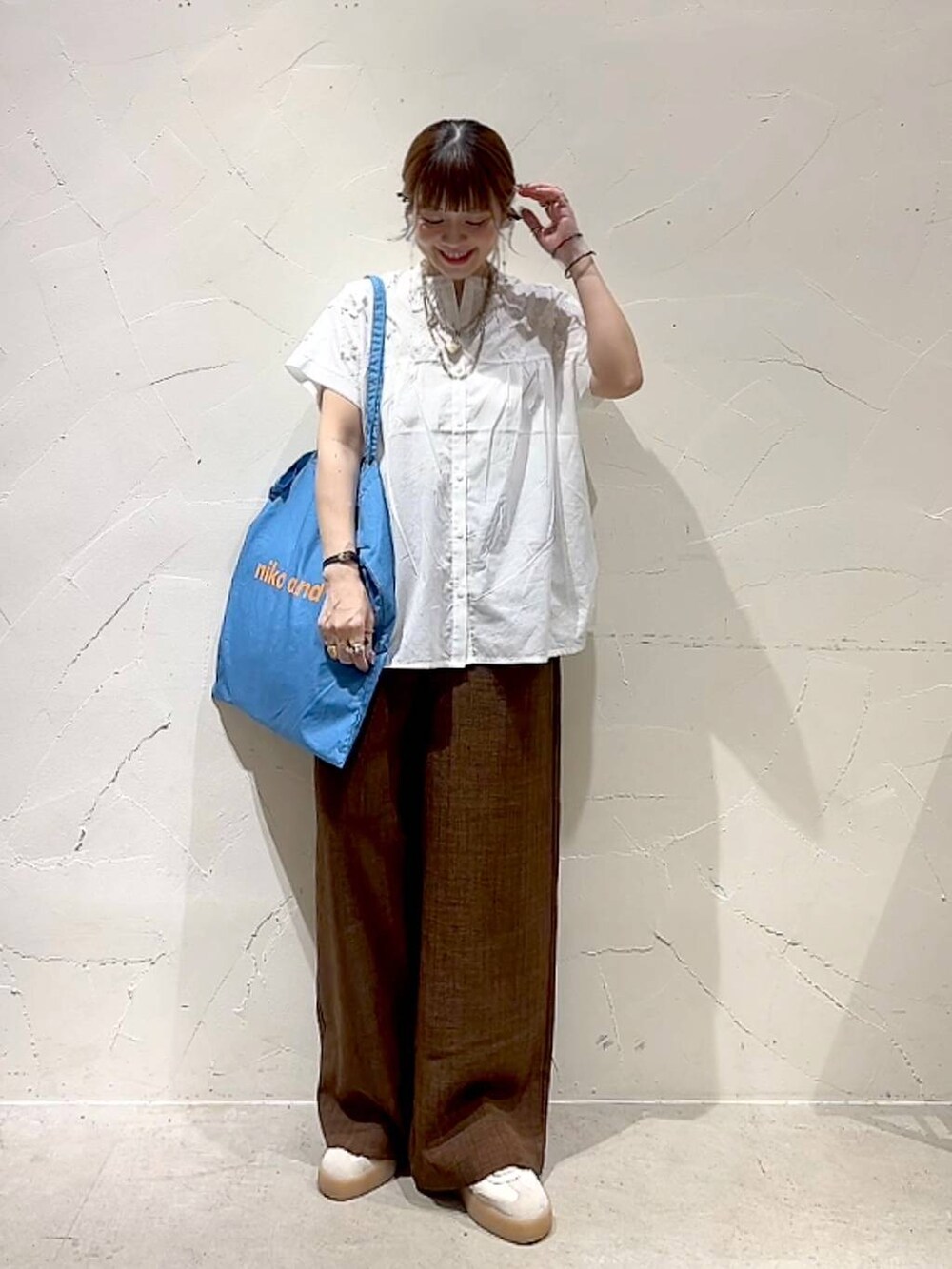 ブルー系のトートバッグ、ホワイト系のシャツ/ブラウス、ブラウン系のその他パンツを着用したレディースの夏コーディネートの9枚目の写真