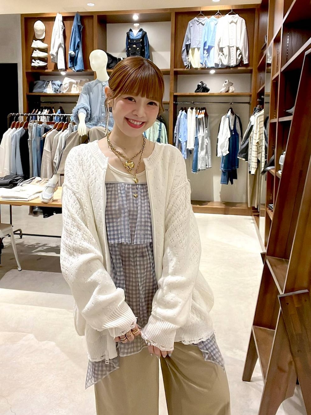ベージュ系のチノパンツ、ホワイト系のブルゾン、ホワイト系のキャミソールを着用したレディースの春コーディネートの2枚目の写真