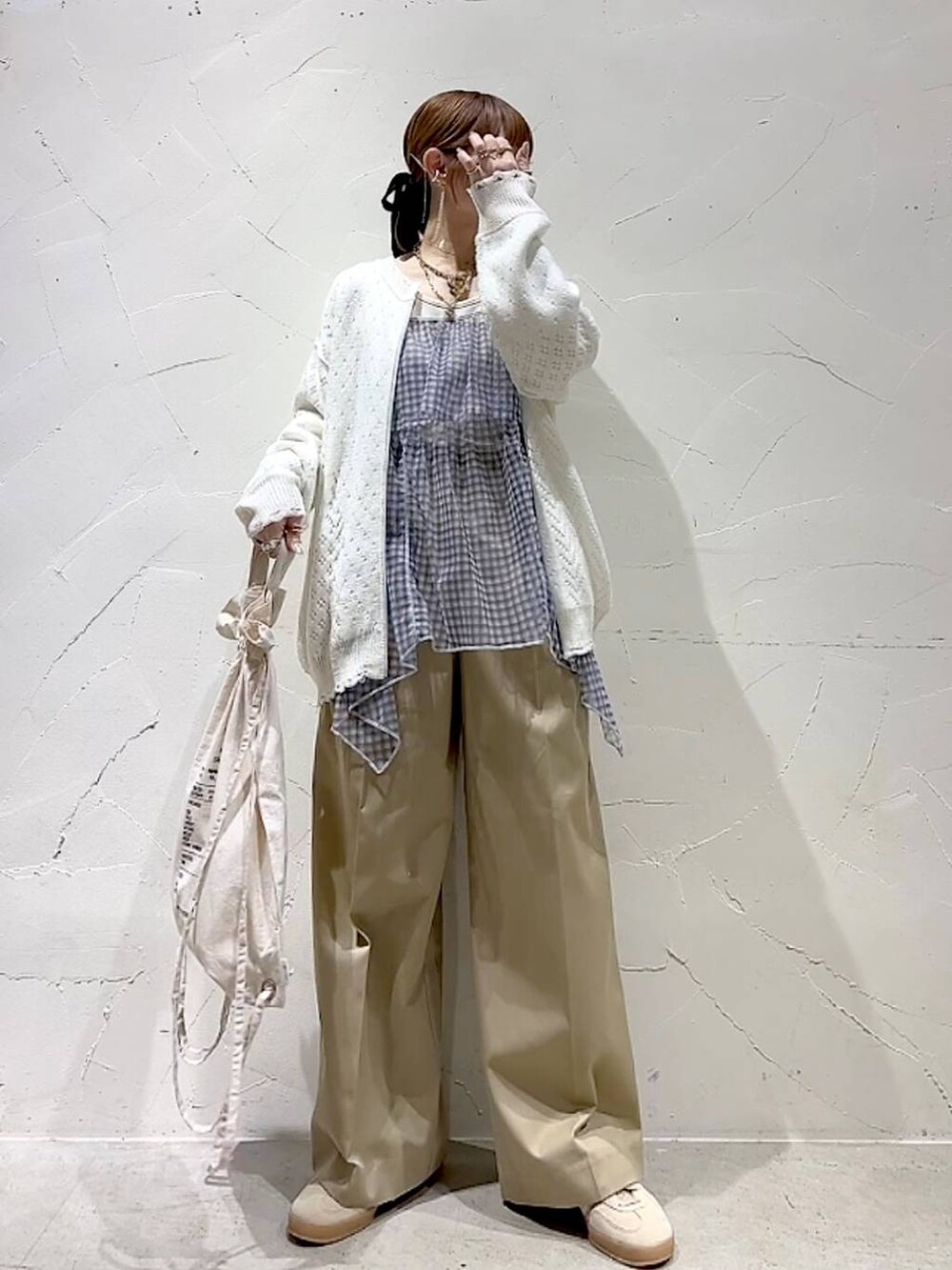 ベージュ系のチノパンツ、ホワイト系のブルゾン、ホワイト系のキャミソールを着用したレディースの春コーディネートの3枚目の写真