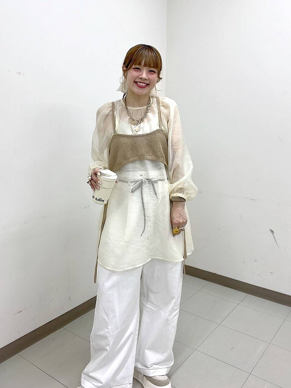 ベージュ系のスニーカー、ゴールド系のリング、グリーン系のアナログ腕時計を着用したレディースの春コーディネートの2枚目の写真