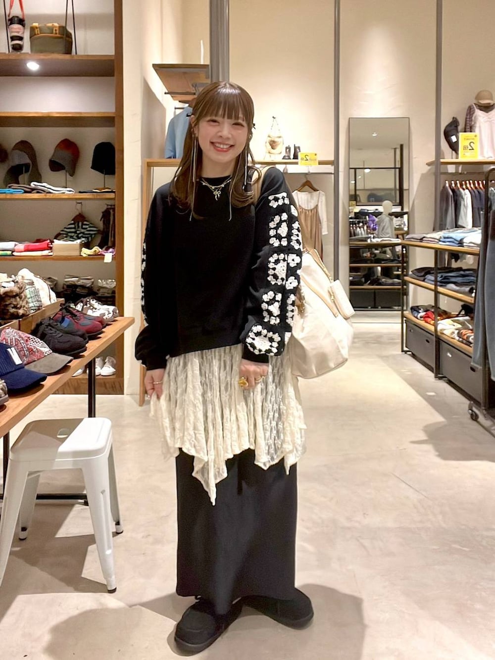ベージュ系のワンピース、ブラック系のスウェット、ブラック系のモカシン/デッキシューズを着用したレディースの秋コーディネートの2枚目の写真