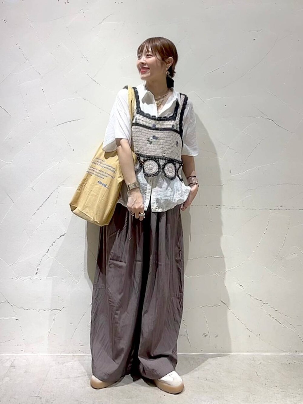 イエロー系のトートバッグ、ホワイト系のキャミソール、ホワイト系のシャツ/ブラウスを着用したレディースの夏コーディネートの8枚目の写真