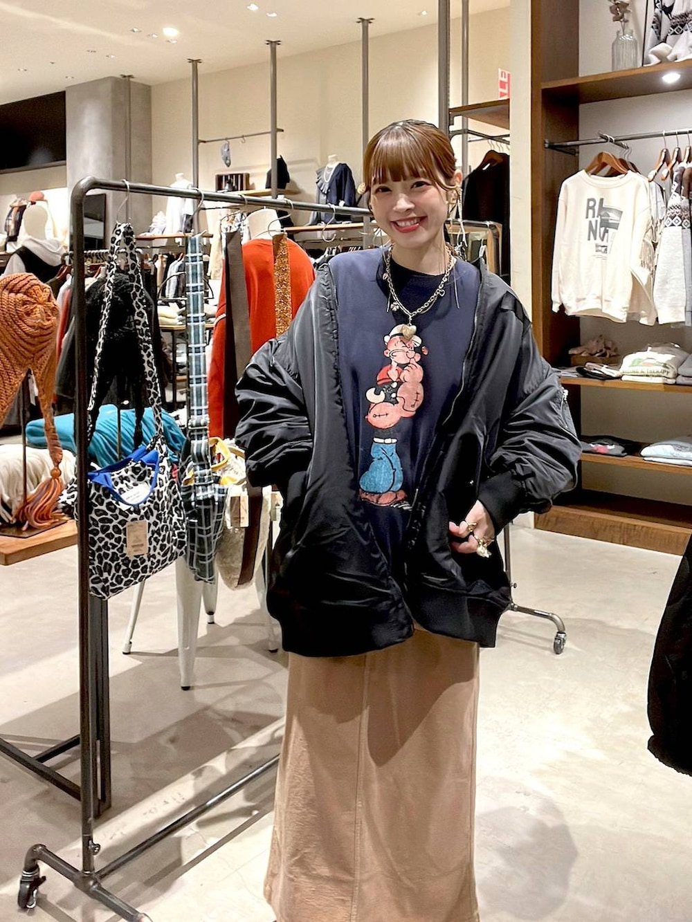 ブラック系のMA-1、イエロー系のスカート、ブルー系のスウェットを着用したレディースの冬コーディネートの2枚目の写真