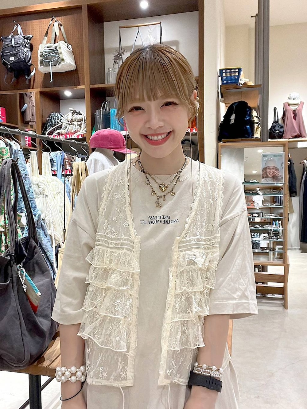 ホワイト系のベスト、ベージュ系のデニムスカート、その他のネックレスを着用したレディースの夏コーディネートの8枚目の写真