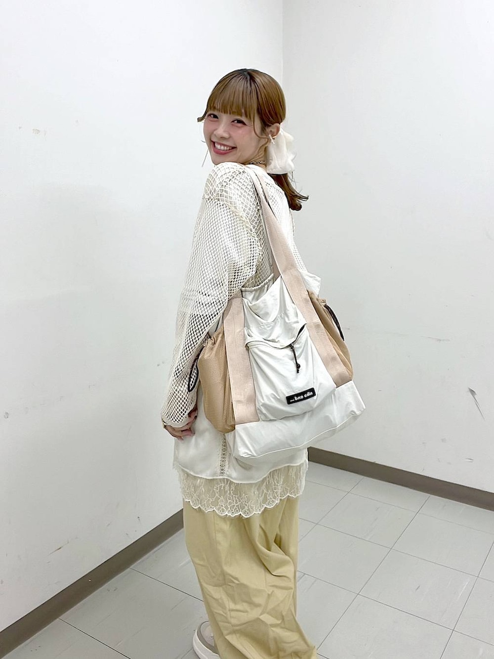 ホワイト系のTシャツ/カットソー、ベージュ系のスニーカー、ベージュ系のトートバッグを着用したレディースの春コーディネートの5枚目の写真