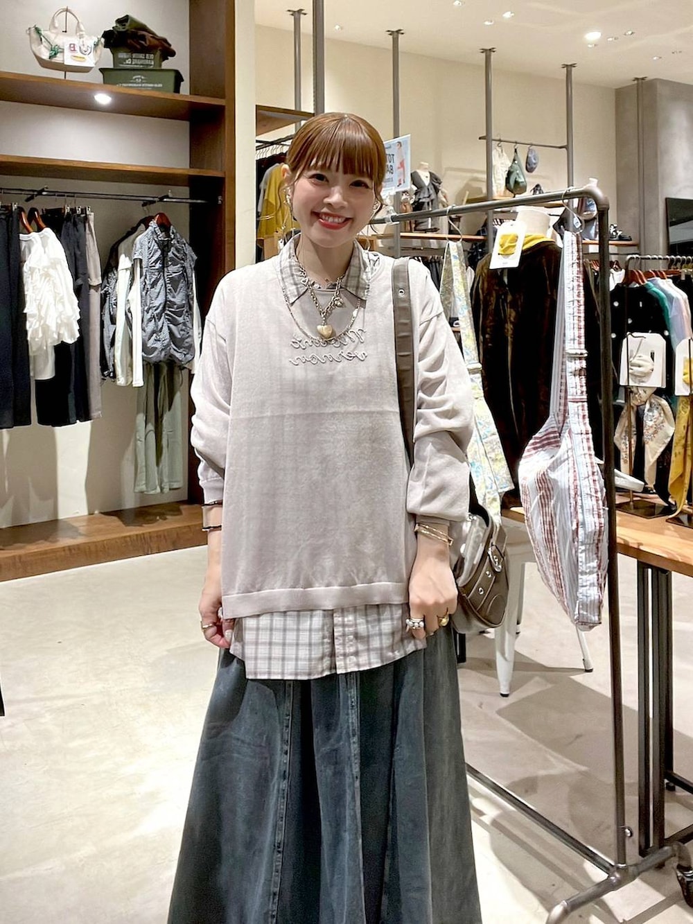 ブルー系のスカート、ホワイト系のシャツ/ブラウス、ブラウン系のショルダーバッグを着用したレディースの秋コーディネートの7枚目の写真