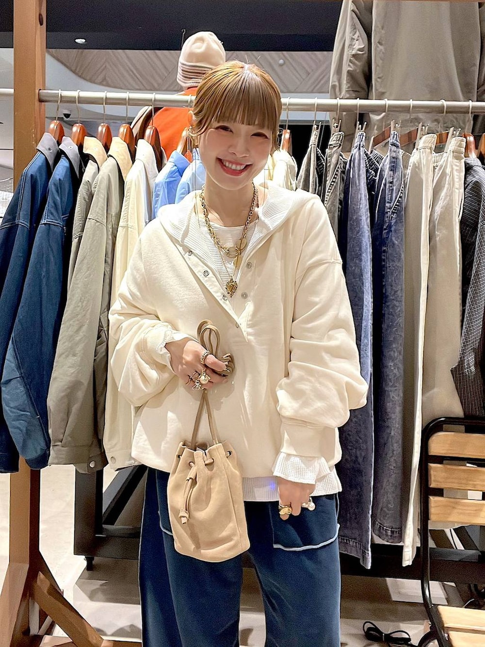 ベージュ系のショルダーバッグ、ホワイト系のパーカー、ホワイト系のTシャツ/カットソーを着用したレディースの冬コーディネートの9枚目の写真