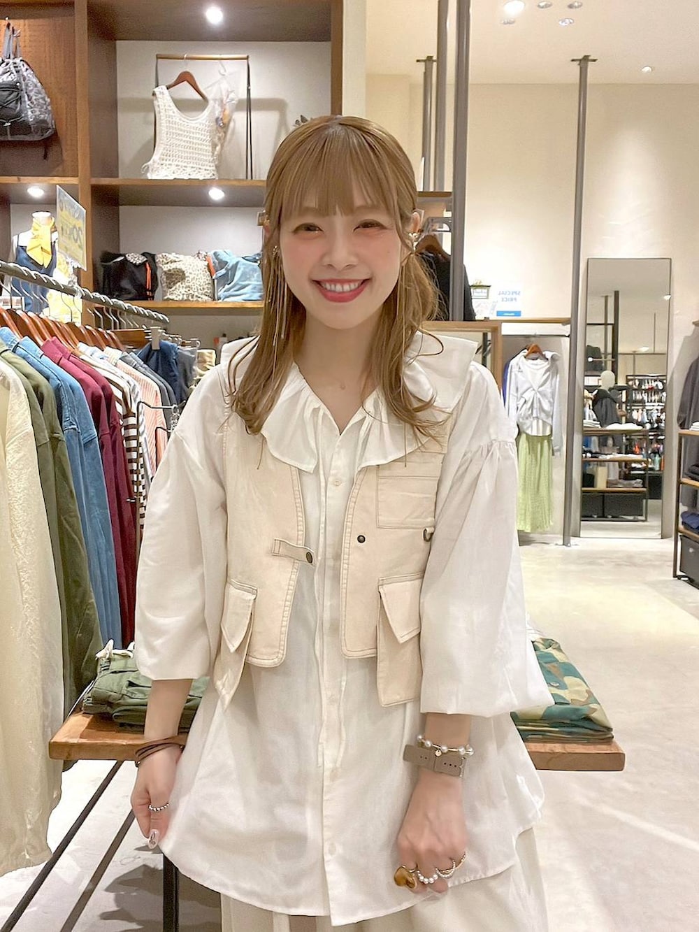 ホワイト系のシャツ/ブラウス、イエロー系のブレスレット、グリーン系のアナログ腕時計を着用したレディースの春コーディネートの4枚目の写真