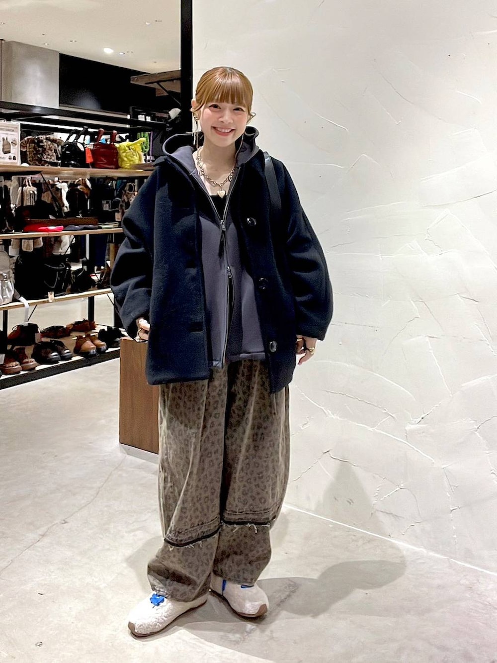 ブラック系のブルゾン、ブラウン系のデニムパンツ、ブラック系のショルダーバッグを着用したレディースの冬コーディネートの9枚目の写真