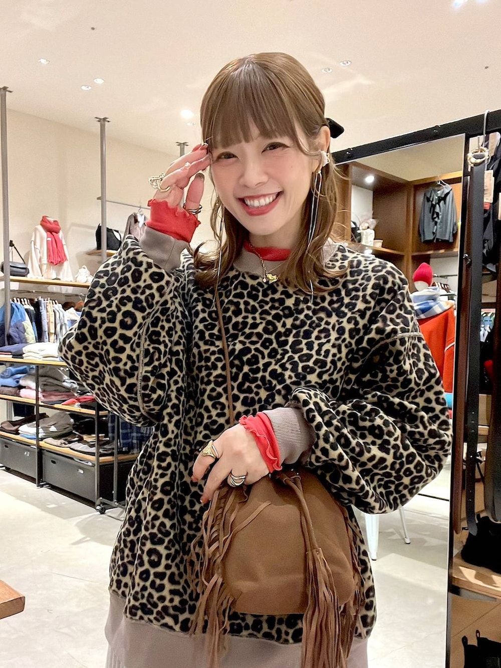 レッド系のTシャツ/カットソー、グレー系のスカート、ベージュ系のスニーカーを着用したレディースの冬コーディネートの7枚目の写真