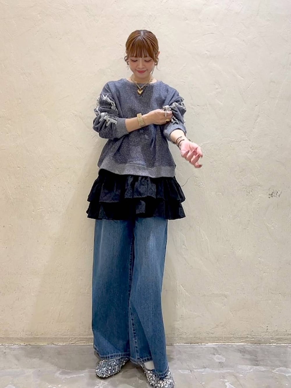 シルバー系のバレエシューズ、ブルー系のデニムパンツ、ブルー系のスウェットを着用したレディースの冬コーディネートの2枚目の写真