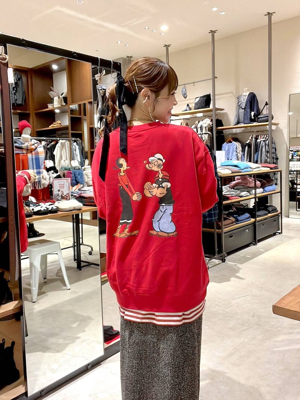 レッド系のTシャツ/カットソー、ホワイト系のスカート、ベージュ系のトートバッグを着用したレディースの冬コーディネートの5枚目の写真