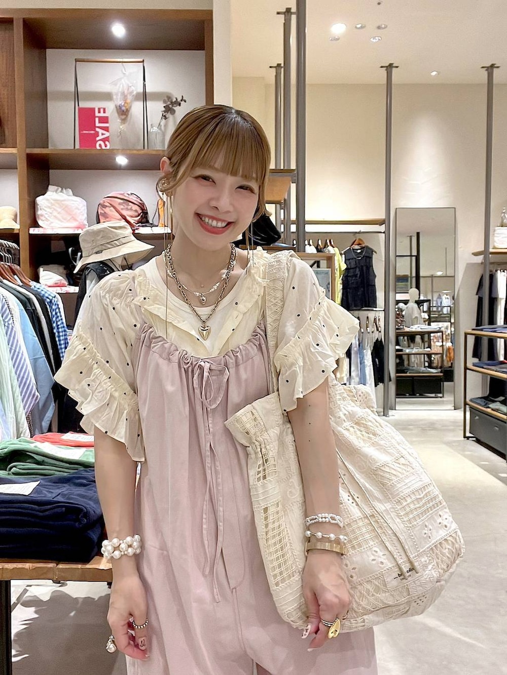 ピンク系のサロペット/オーバーオール、ベージュ系のトートバッグ、ホワイト系のシャツ/ブラウスを着用したレディースの夏コーディネートの2枚目の写真