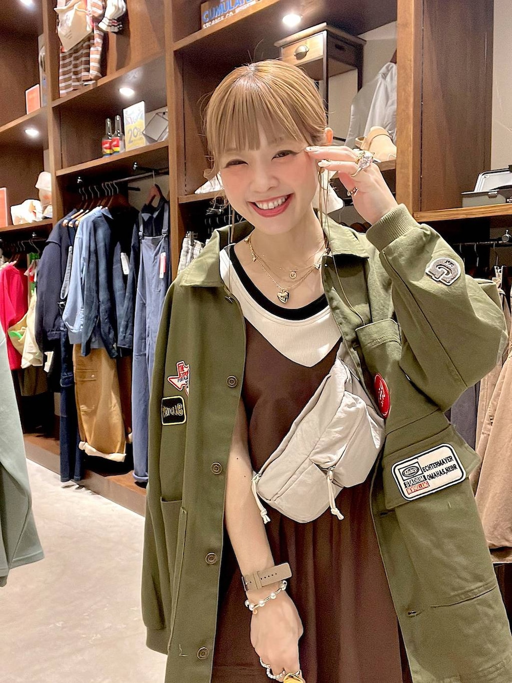 ピンク系のデニムパンツ、ホワイト系のタンクトップ、イエロー系のブレスレットを着用したレディースの春コーディネートの4枚目の写真