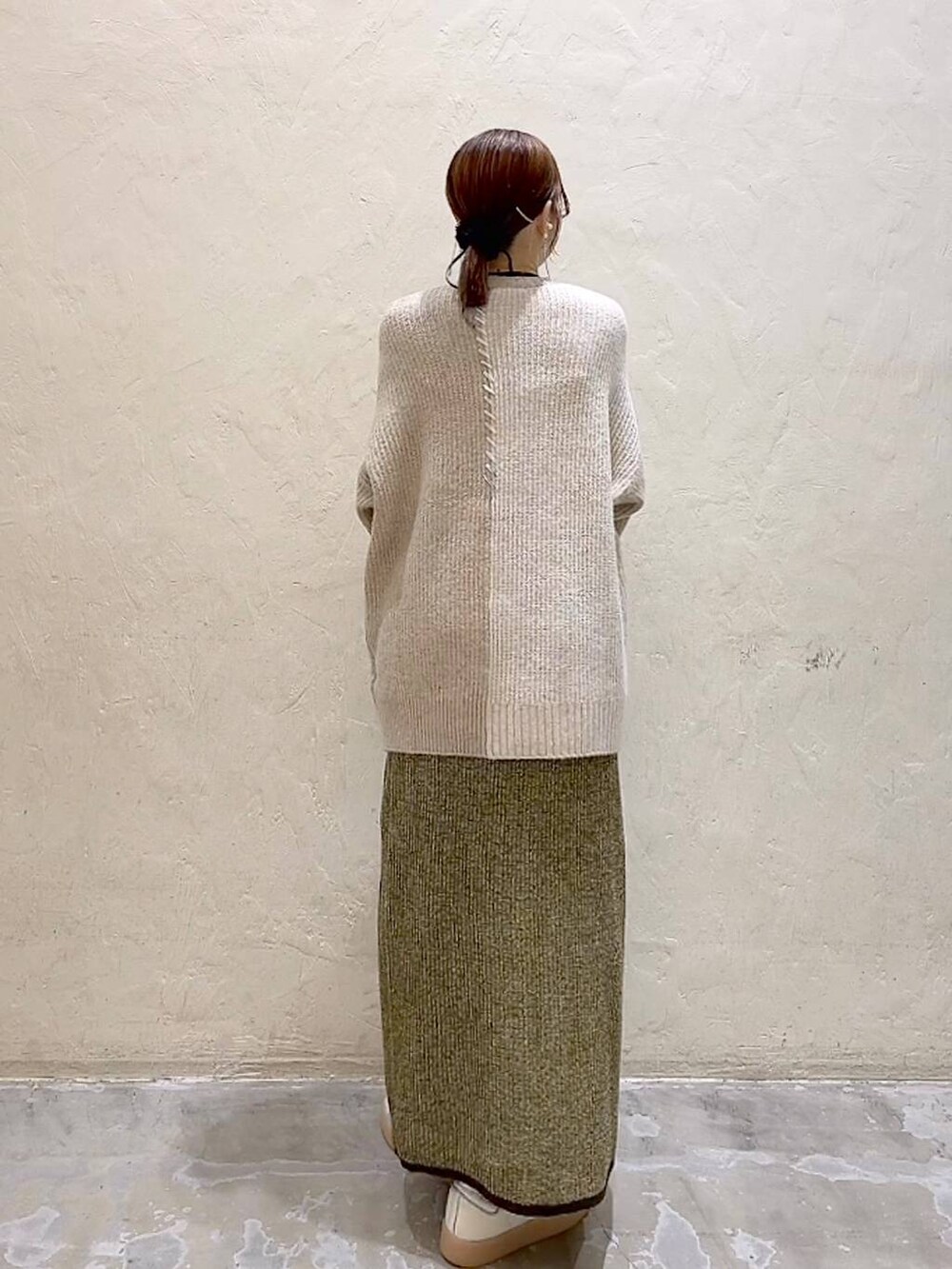 イエロー系のスカート、ベージュ系のニット/セーター、ブラック系のチョーカーを着用したレディースの秋コーディネートの5枚目の写真