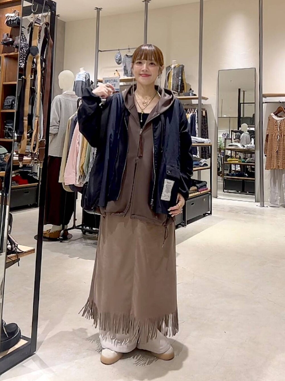 ブラウン系のスカート、ブラウン系のパーカー、ベージュ系のその他パンツを着用したレディースの秋コーディネートの9枚目の写真