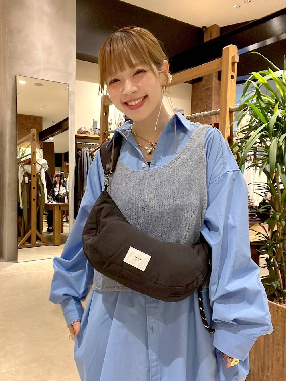 ブルー系のシャツ/ブラウス、ブラック系のショルダーバッグ、ブラウン系のチュニックを着用したレディースの秋コーディネートの5枚目の写真